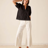 Women's travel-friendly black short-sleeved button-front tunic top with a notched collar.