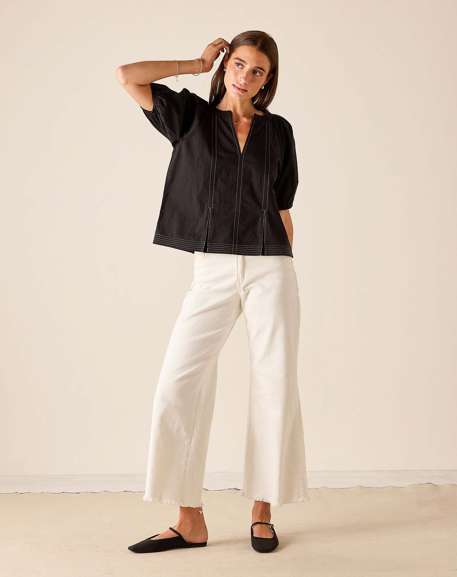 Women's travel-friendly black short-sleeved button-front tunic top with a notched collar.
