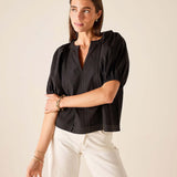 Black puff-sleeved woven cotton blouse with button front and textured detail.