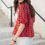 Crimson striped shirt with puffed sleeves and floral embroidery.