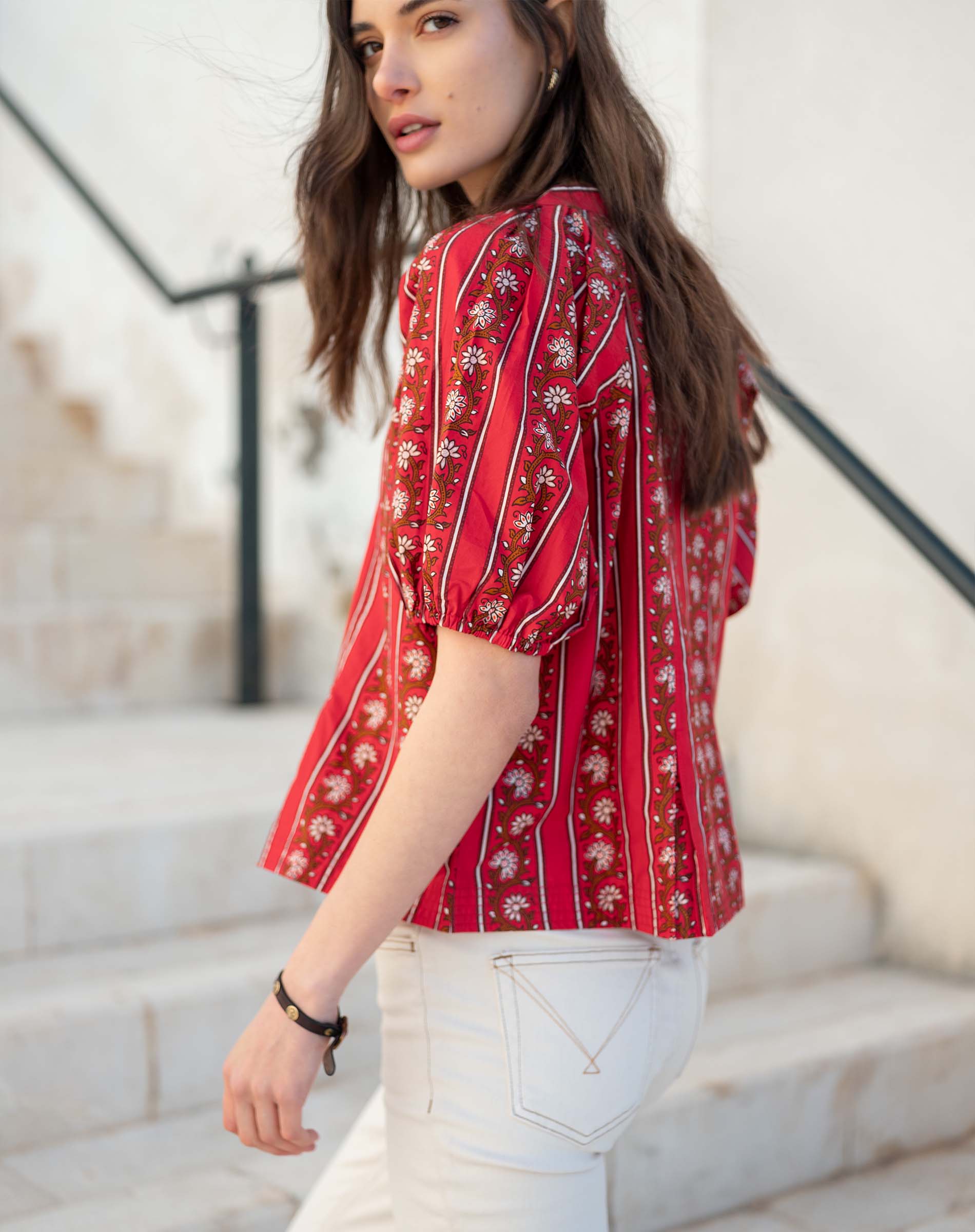 Crimson striped shirt with puffed sleeves and floral embroidery.