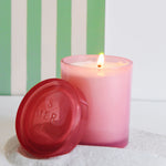 joli jar candle lit with a green striped backdrop