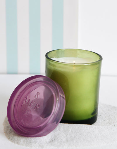 joli jar candle lit with a green striped backdrop
