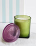 joli jar candle lit with a green striped backdrop