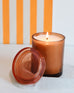 joli jar candle lit with a orange striped backdrop