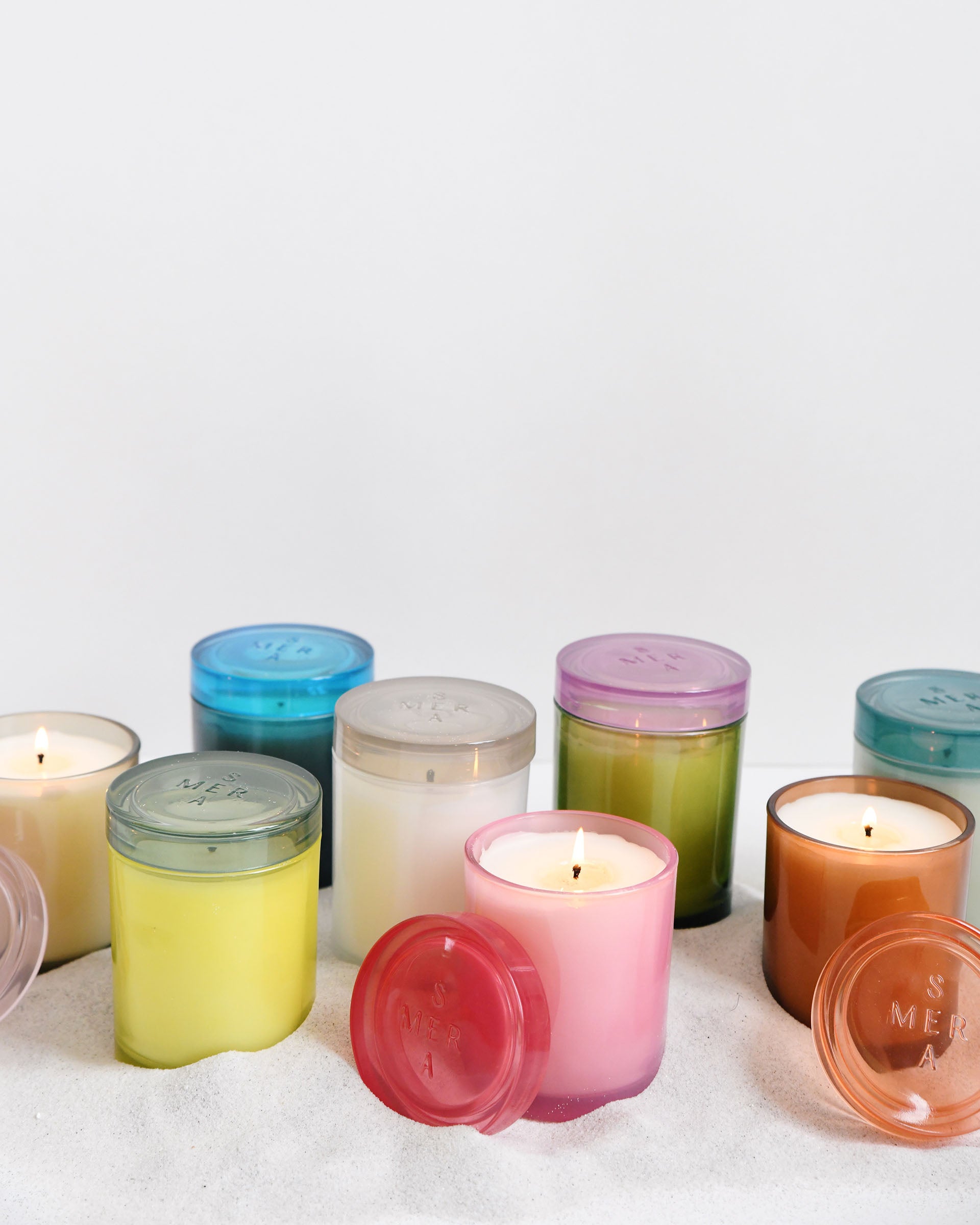 group shot of all joli jar candles sitting in sand