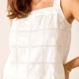 White sleeveless top worn by a person on a plain background