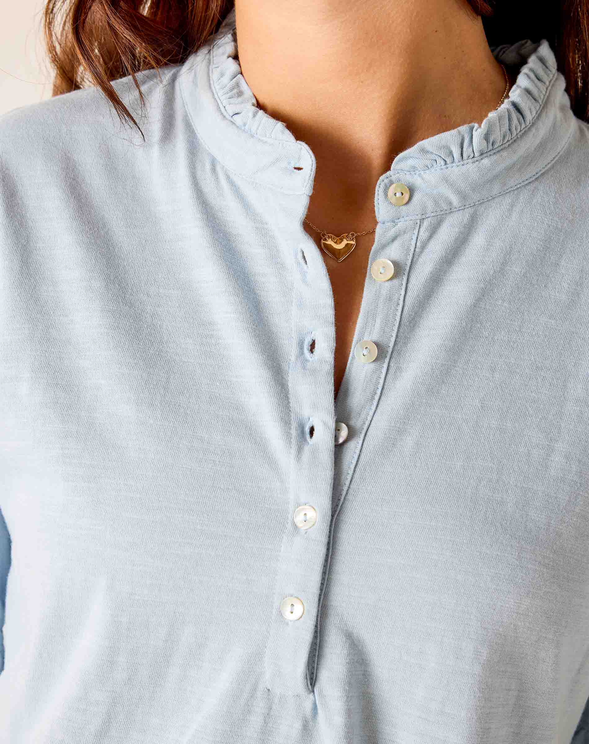 Light blue button-up shirt worn by a person with a neutral background