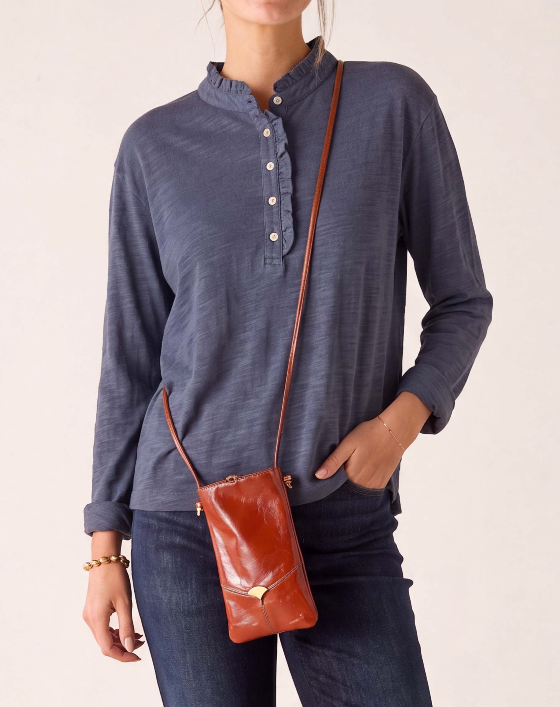 MERSEA ladies' travel-ready muted blue long-sleeve ruffled henley top.