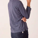 Dusty blue long sleeve ruffle henley knit top with a side view of the model wearing dark denim jeans