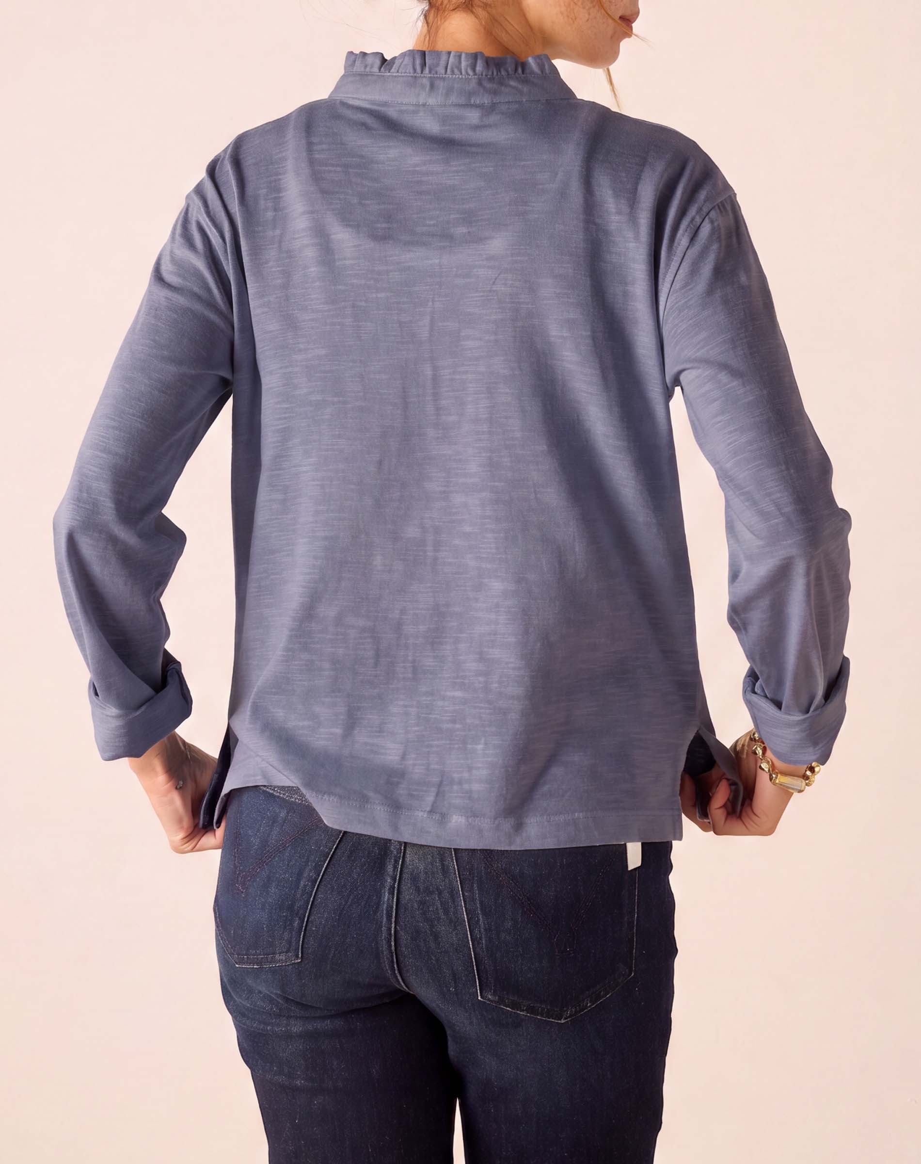 Back view of the blue long sleeve ruffled henley top.