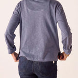 Back view of women's travel-friendly blue ruffled henley top with long sleeves and high-neck detail.