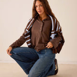 Women's travel-friendly espresso brown long-sleeved Henley top featuring ruffle details and a buttoned neckline.
