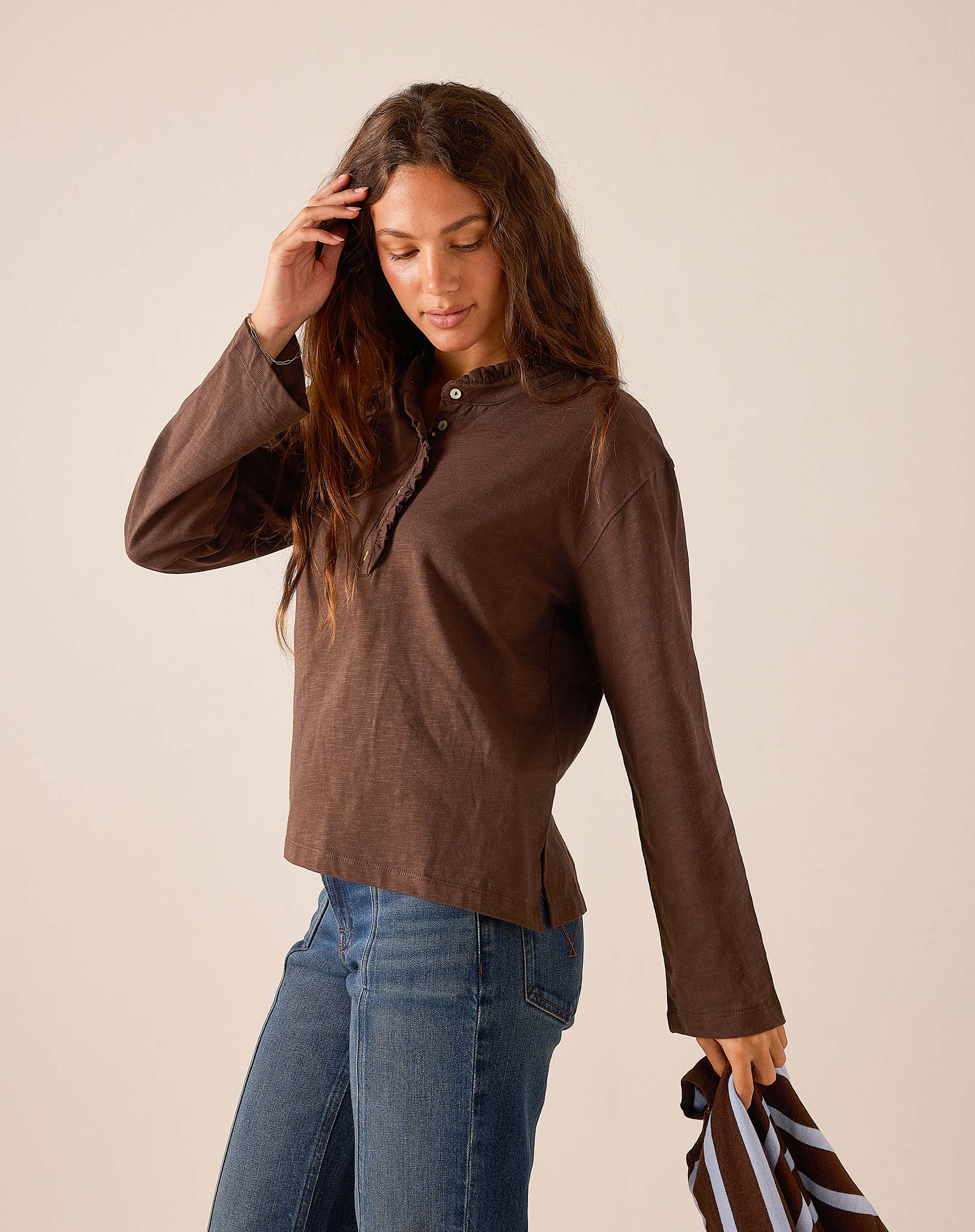 Espresso brown long sleeve ruffle henley top in a lightweight knit fabric.