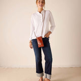 MERSEA ladies' travel-ready white long-sleeve ruffle henley top with a buttoned neck.
