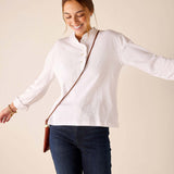 White long-sleeve ruffle henley top with a buttoned collar and textured fabric.