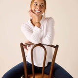 White long-sleeve ruffle henley top with a textured knit finish.