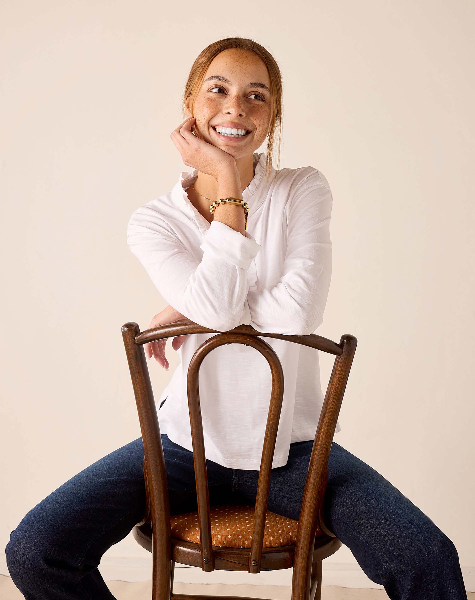 White long-sleeve ruffle henley top with a textured knit finish.