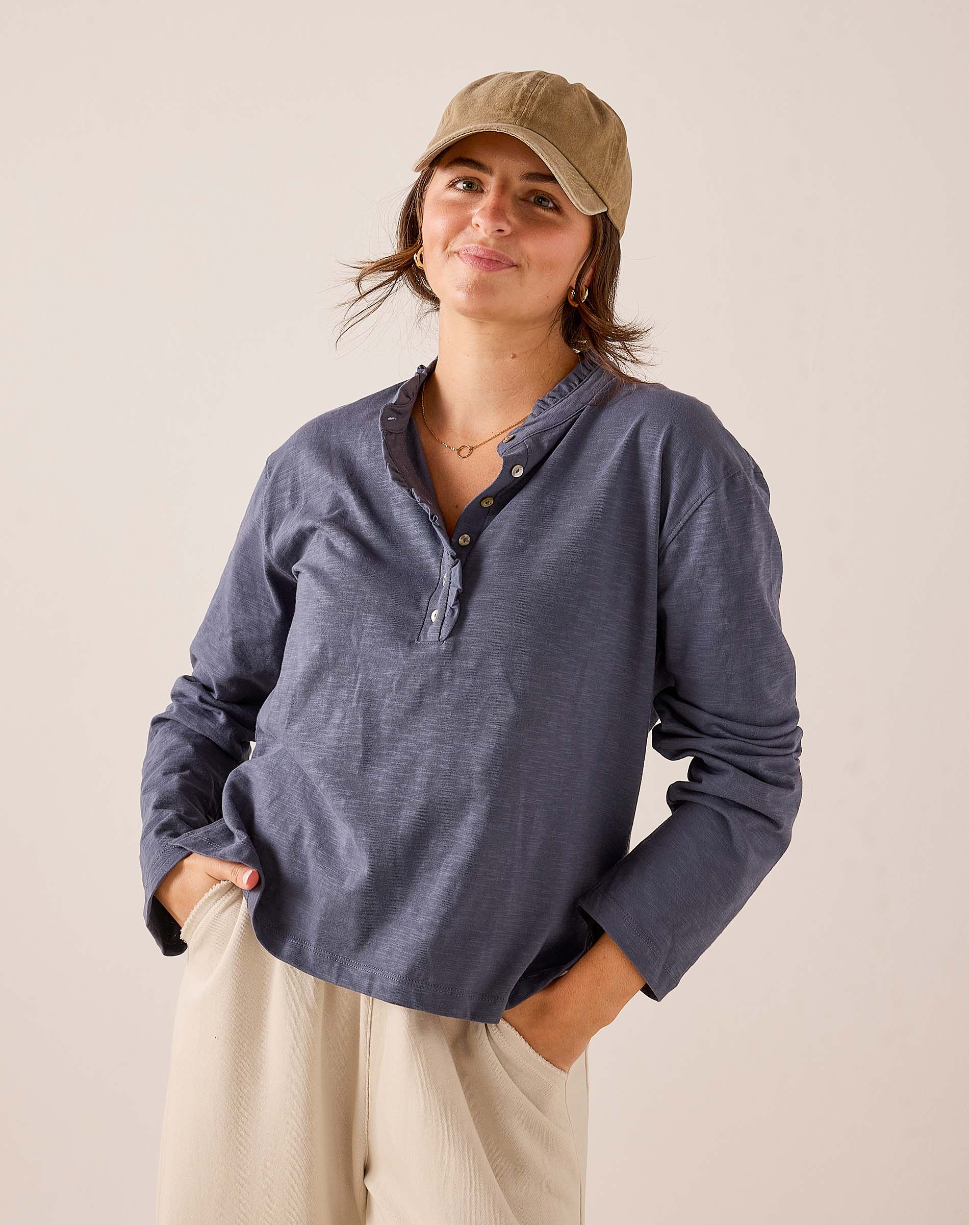 Indigo blue long-sleeve jersey tee with a buttoned henley neckline and relaxed fit.