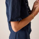 Person wearing a navy blue outfit with a plain background