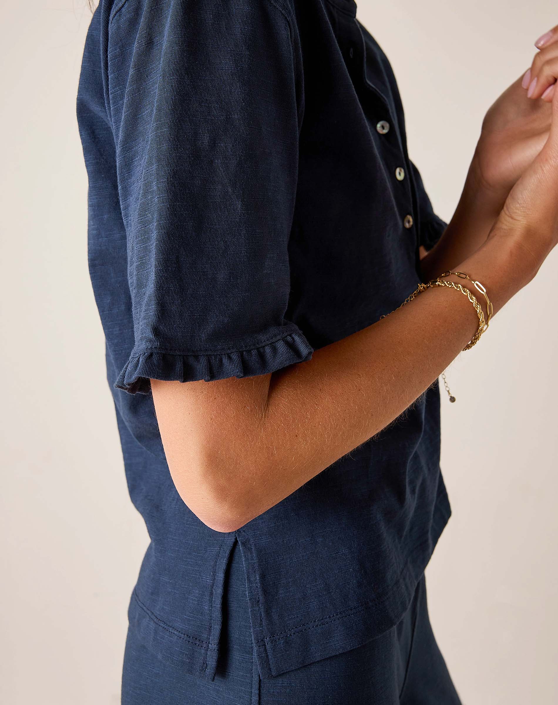 Person wearing a navy blue outfit with a plain background