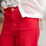 Red pants with a white shirt worn by a person, blurred background