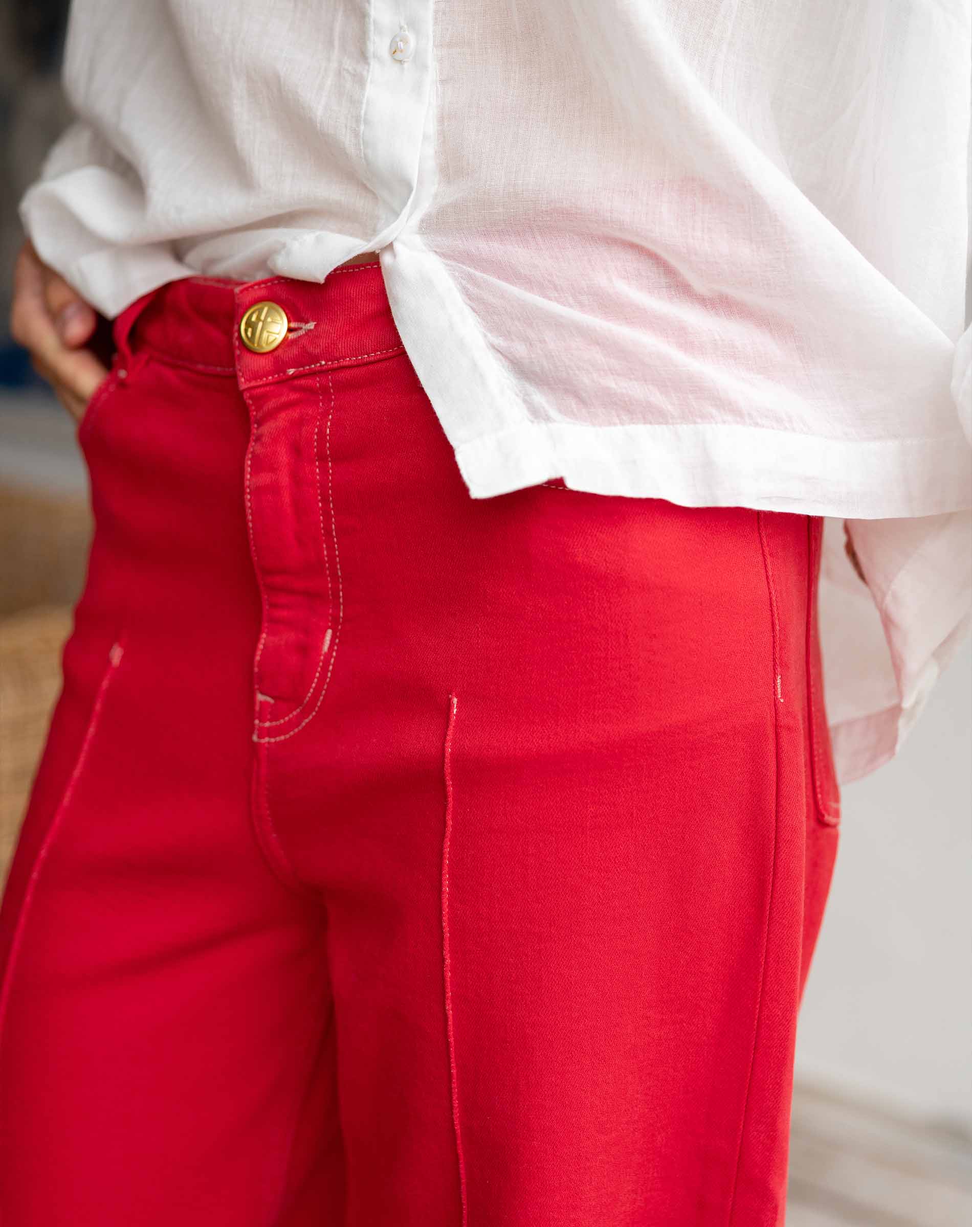Red pants with a white shirt worn by a person, blurred background