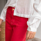 Person wearing a white shirt and red pants with a blurred background