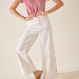 Person wearing a red and white striped shirt and white pants on a plain background