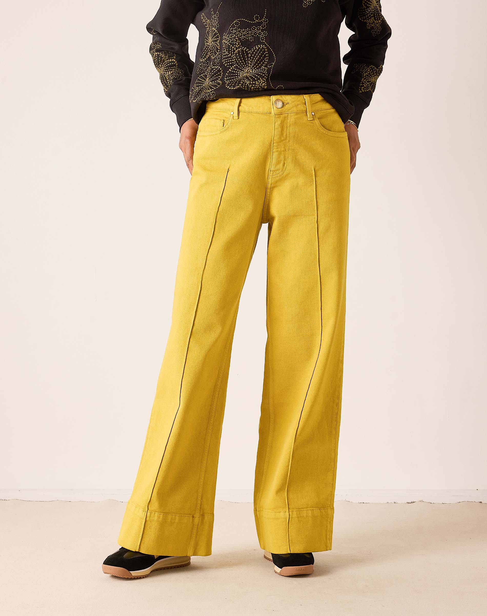 Mustard yellow wide-leg 5-pocket jeans with vertical seams and a relaxed fit.