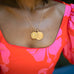 woman wearing two mersea colab zodiac pendants with chain
