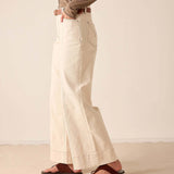 Oat-colored wide-leg trousers with side pockets and a relaxed fit.