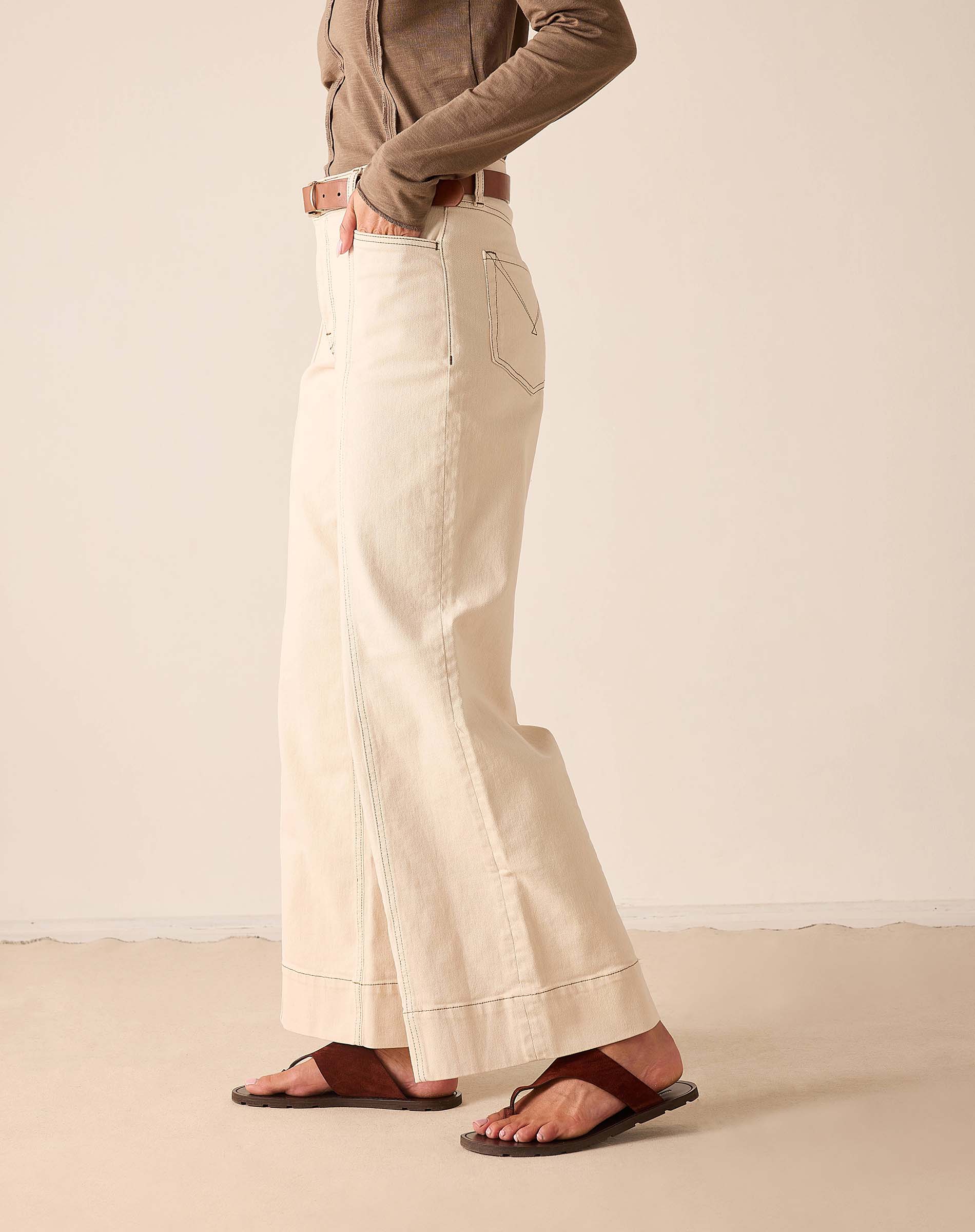 Oat-colored wide-leg trousers with side pockets and a relaxed fit.
