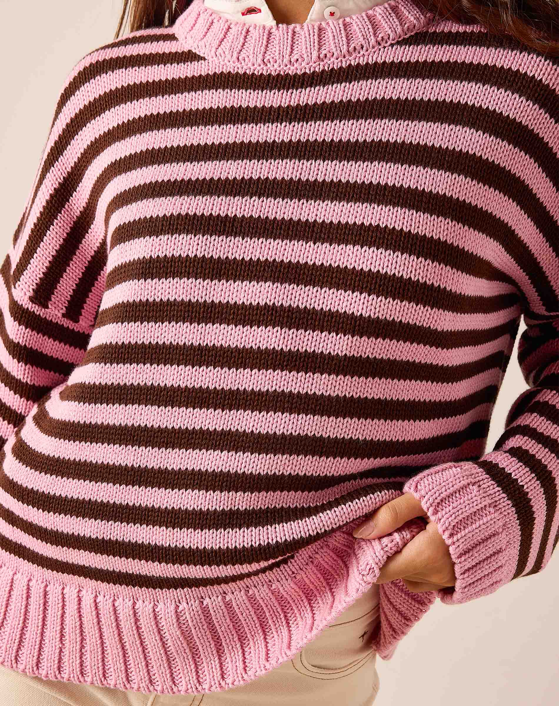 Pink and brown striped knit cotton crewneck sweater with a ribbed neckline and hem.