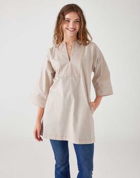 woman showcasing mersea bone white tunic dress with v neck