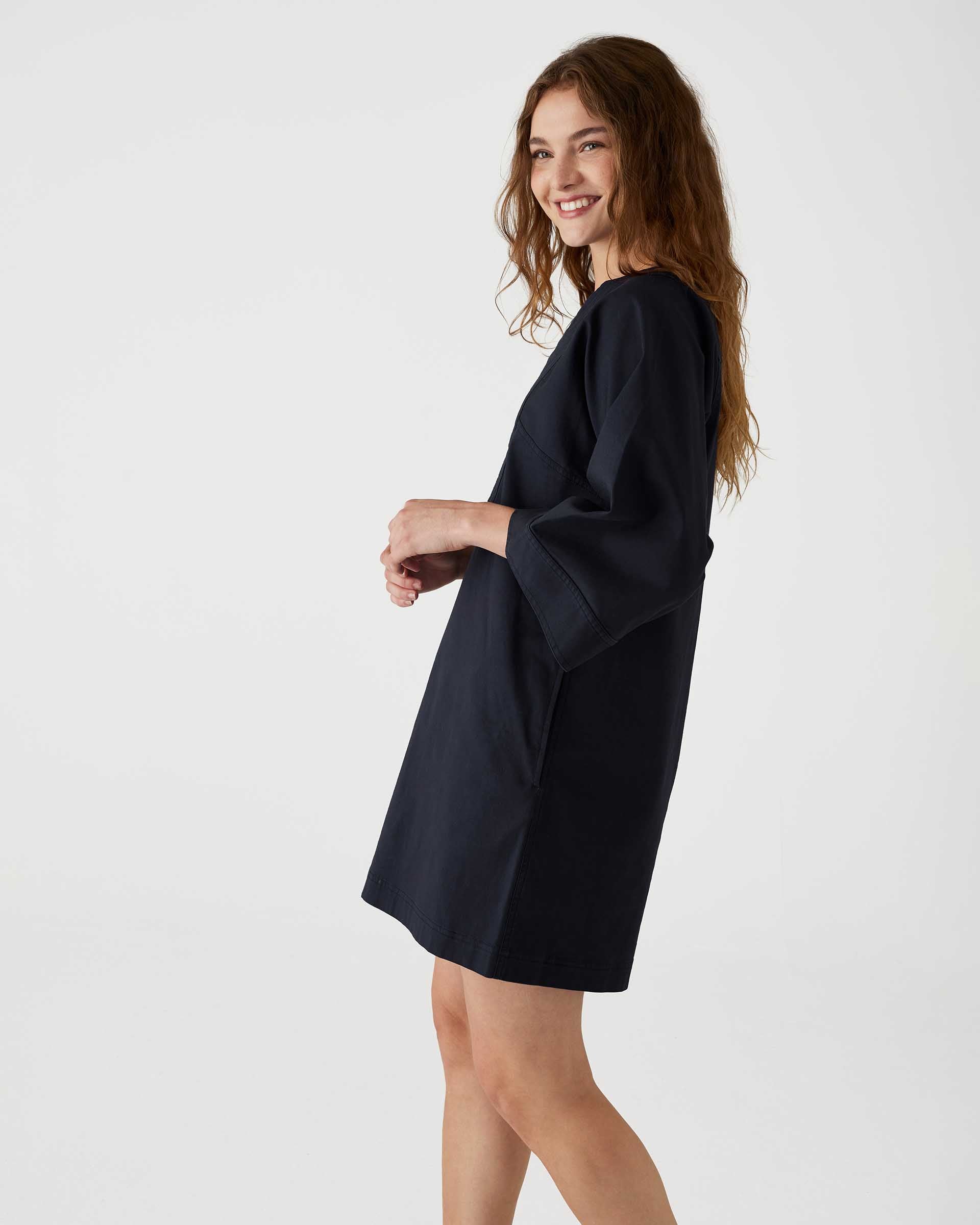 profile of woman showcasing mersea navy tunic dress with v neck