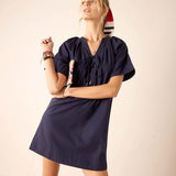 Woman wearing a navy blue dress with a plain background
