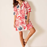 Woman wearing a red and white patterned dress against a plain background