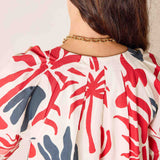 Person wearing a red and blue patterned garment with a neutral background