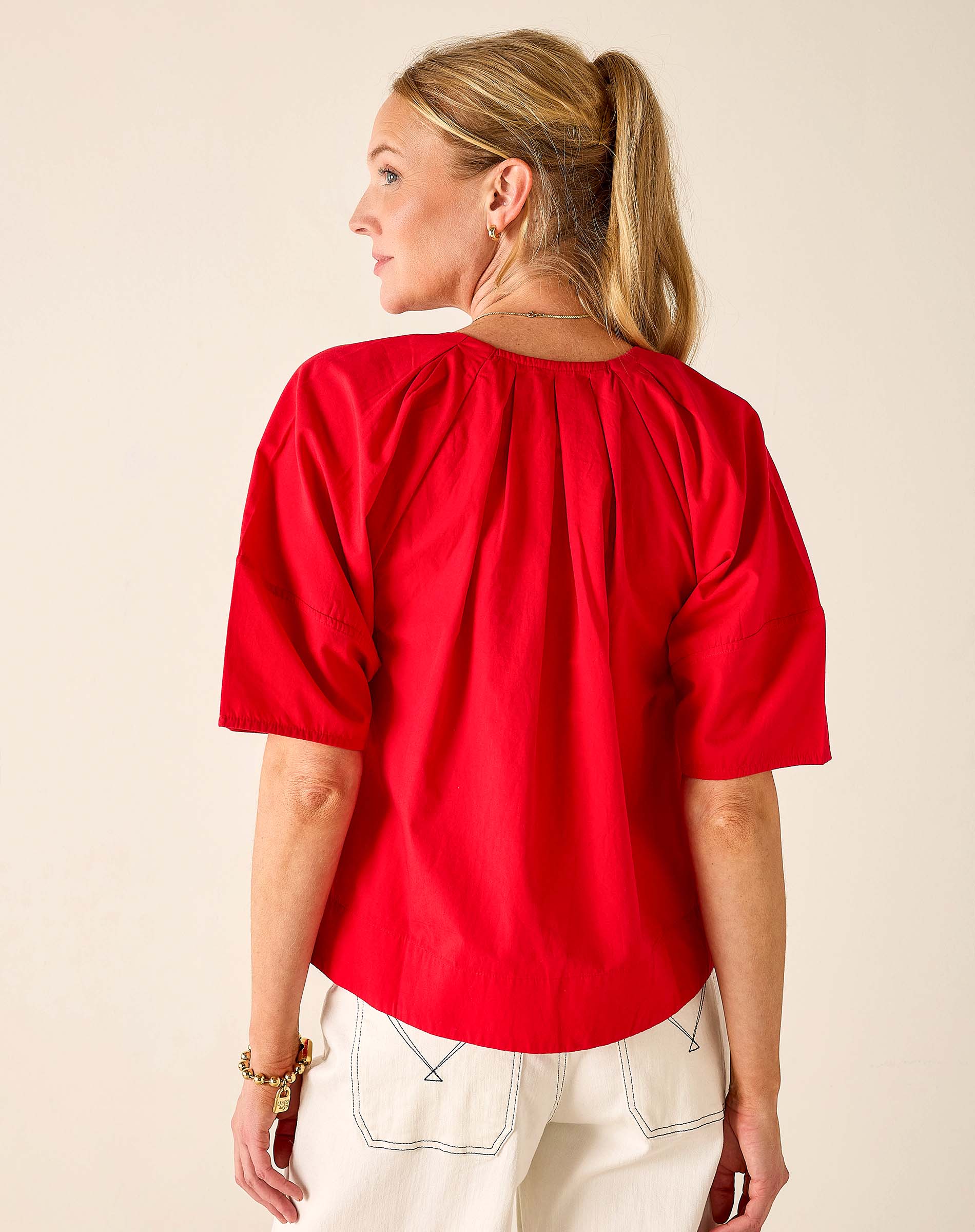 Woman wearing a red blouse with a plain background