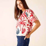 Woman wearing a colorful patterned shirt with a plain background