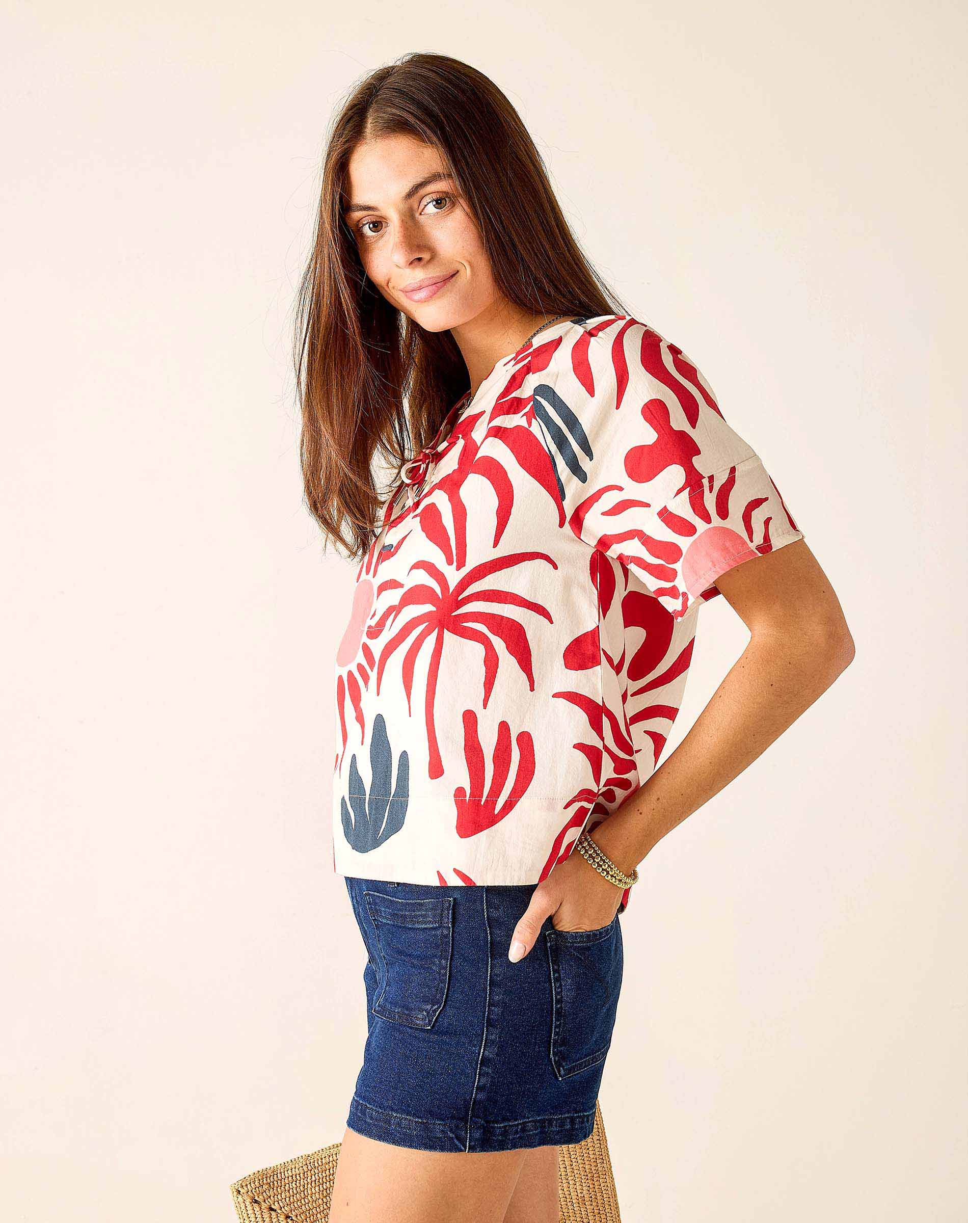 Woman wearing a colorful patterned shirt with a plain background