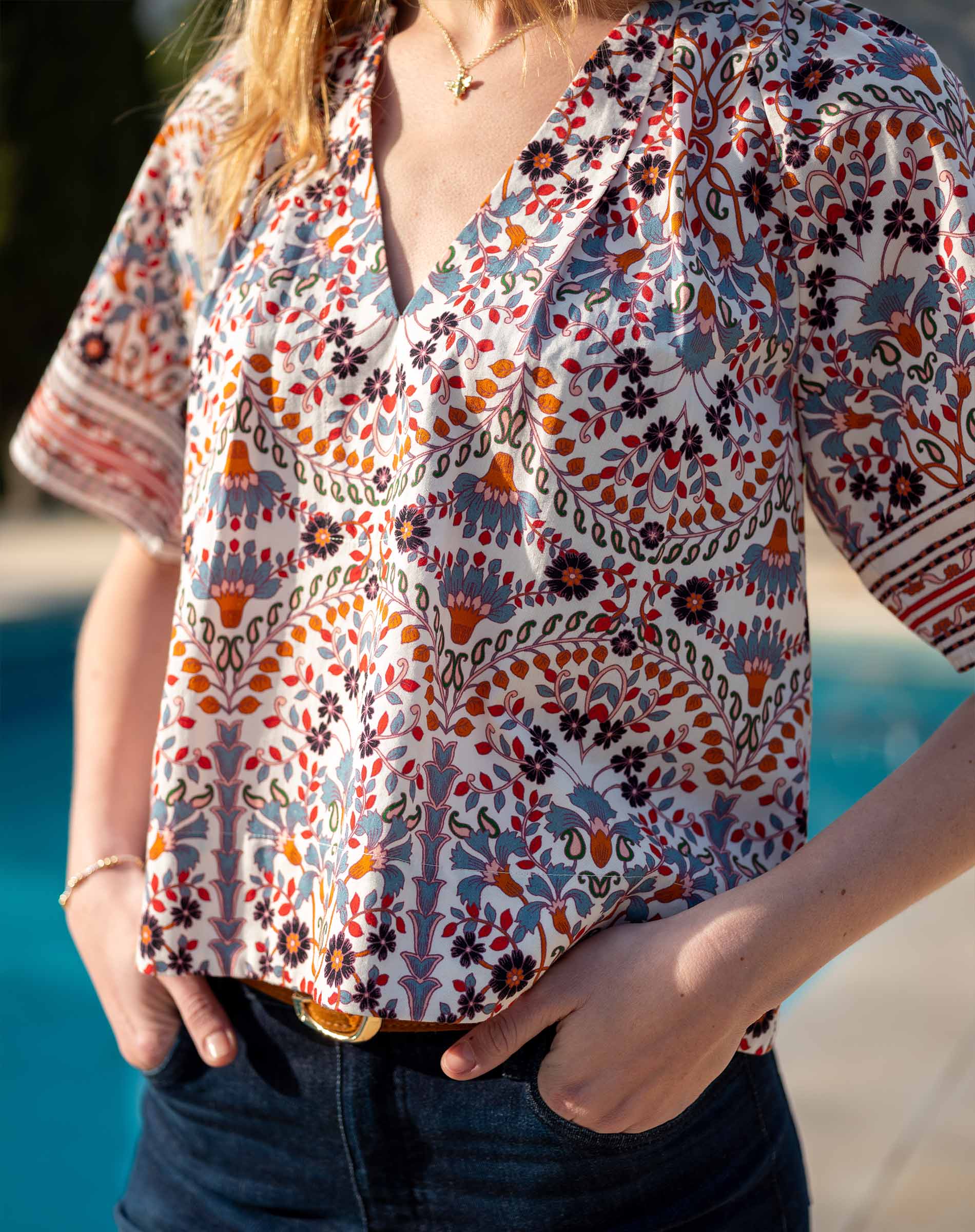 Multi-colored arched floral print top with a v-neckline and short sleeves.