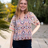 Multi-colored arched floral print lace top with short sleeves.