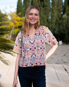 Multi-colored arched floral print lace top with short sleeves.