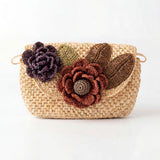 Woven handbag with floral embellishments on a white background