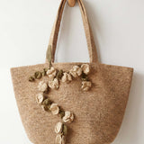 Woven tote bag with floral decorations on a white background