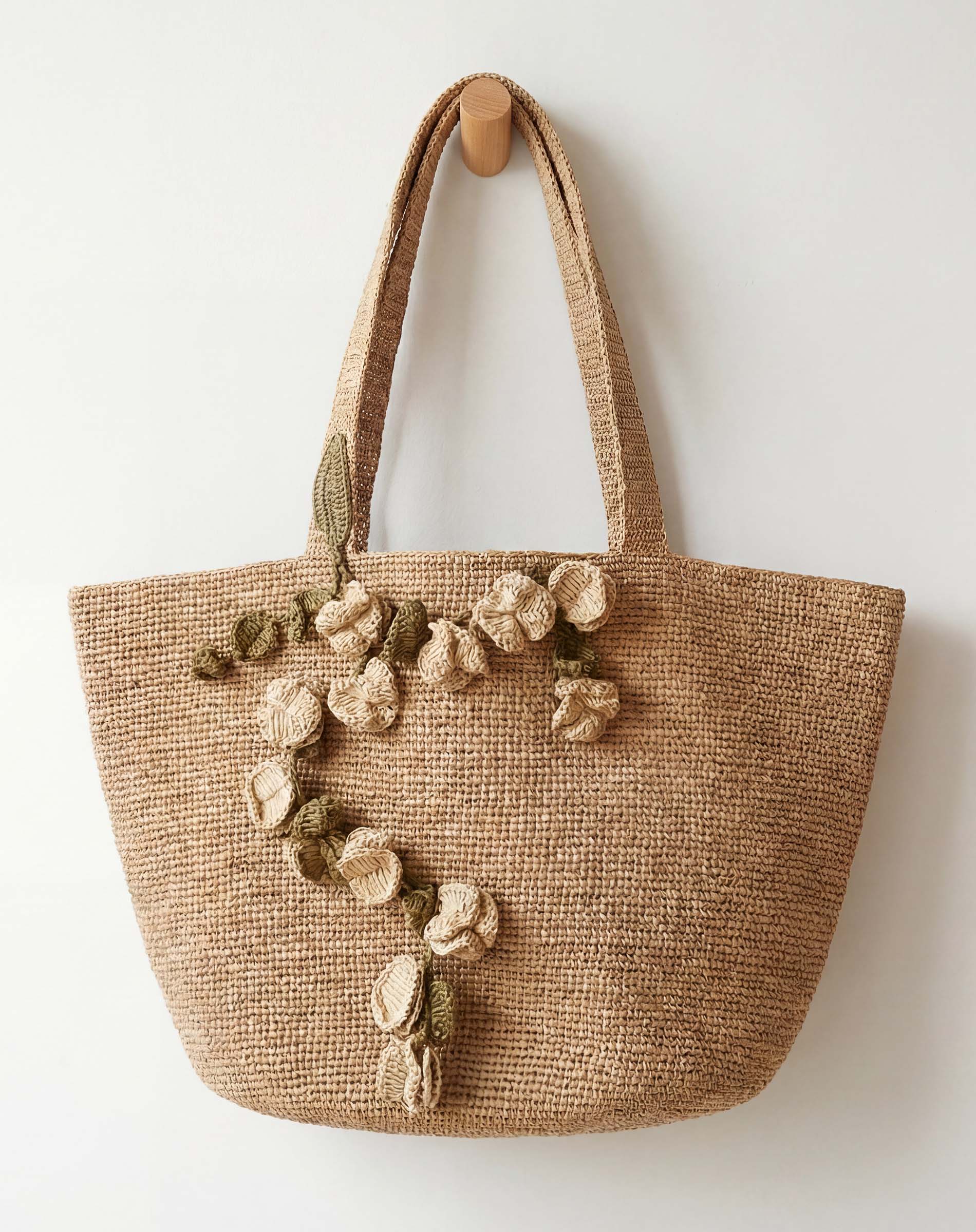 Woven tote bag with floral decorations on a white background