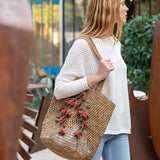 Woman carrying a woven bag with floral decorations outdoors