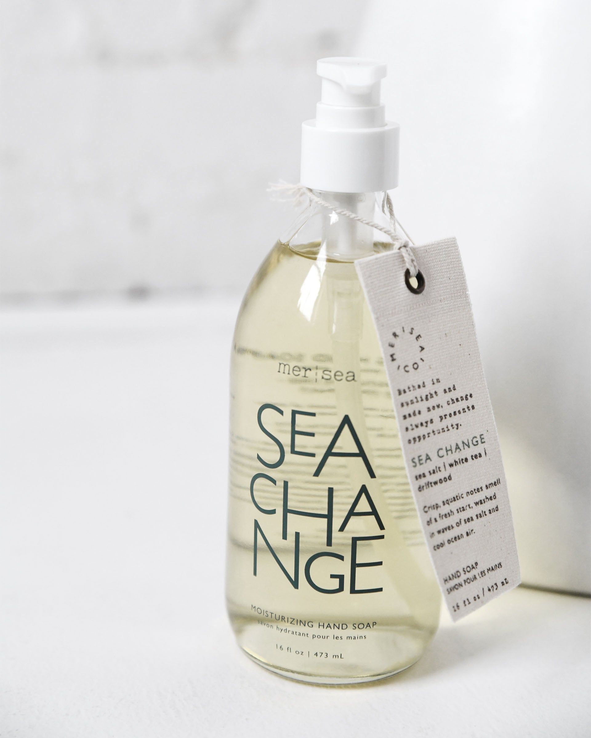 large sea change liquid hand soap sitting on white counter